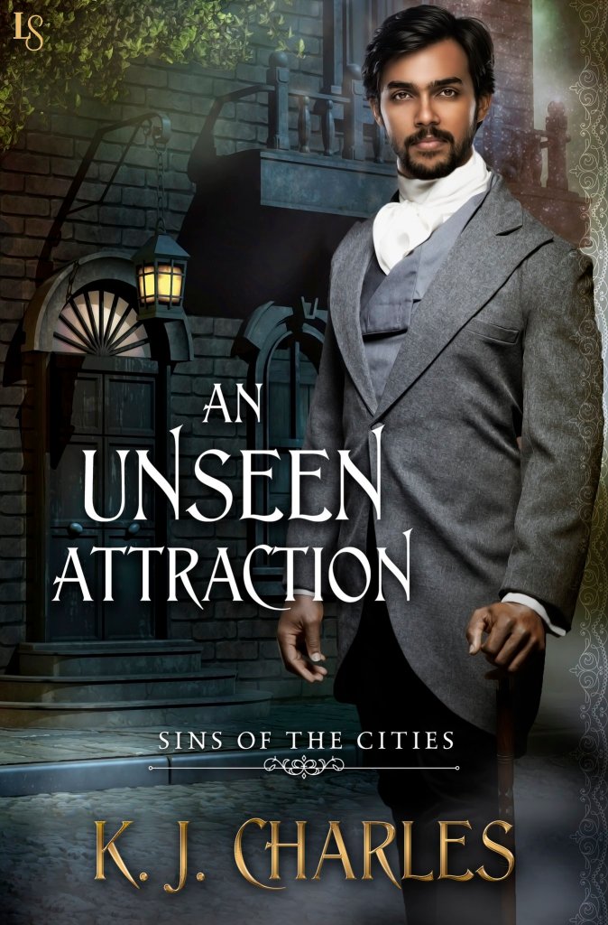 A book cover. The title, "An Unseen Attraction" is in large white print, lower centre of the image. At the bottom of the cover, in large gold print, the authors name "K. J. Charles". Directly above this, in smaller, white print, the phrase "Sins of the Cities". All of the text is in caps. 
The figure of a man takes up the right half of the image. He is of Indian descent, has black hair, black facial hair, is wearing a grey suit, and is staring out of the cover at the reader. Behind him, a dark street scene. There is a house with a lit lamp outside of it. The house has a balcony, and there is a tree next to it. It appears to be night time. /end