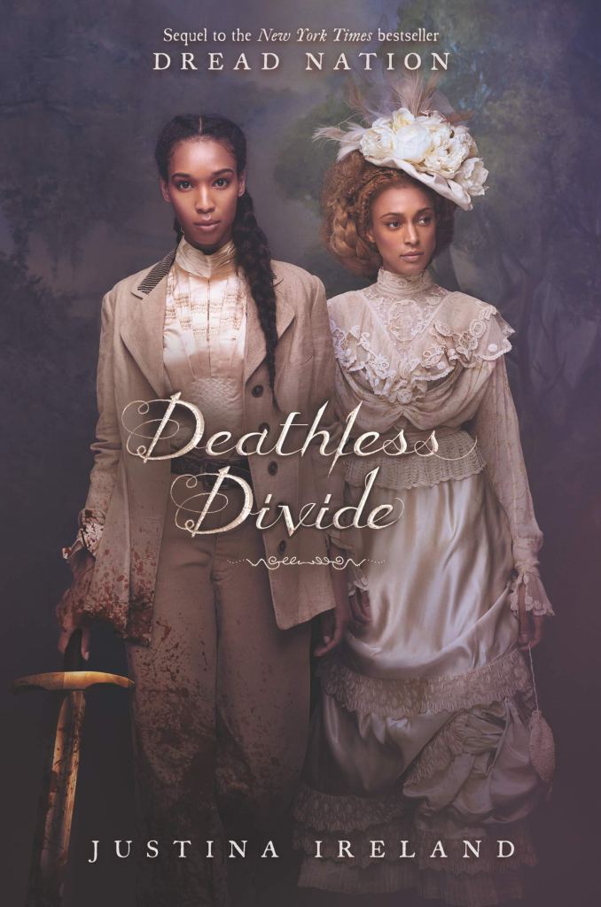 A book cover. The background is a light black. The figures of two young black women are in the foreground. They are wearing 19th-century-era clothing. The woman on the left has dark black braided hair and is wearing a beige suit. She has a sword in her right hand and blood down her lower right side. The woman on the right has curly brown hair and is wearing a long white dress and matching hat.
White text at the top of the cover reads "Sequel to the New York Times bestseller Dread Nation". "Dread Nation" is in caps.
The title "Deathless Divide" is written in the centre of the cover, in white, styled italics.
The author's name "Justina Ireland" is at the bottom of the cover in white caps. /end