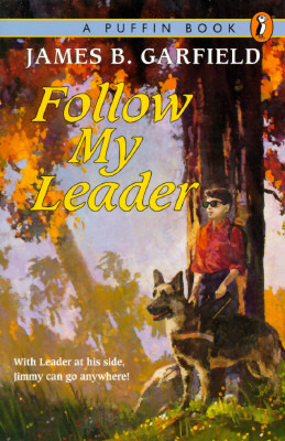 A book cover. The background is a painting that shows a young boy wearing a red shirt and black glasses with dark lenses. He is standing under a large tree and has a German Shepherd dog at his side. They are outside and it is sunny. The tree has orange leaves. At the top of the cover, a blue band with the words "A Puffin Book" in black caps in the top right corner. The logo of a puffin in an orange oval is next to it. Underneath the band, the author's name "James B. Garfield" in larger white caps. Underneath this, the title "Follow My Leader" in larger, yellow italics. The phrase "With Leader at his side, Jimmy can go anywhere!" is written in small white writing in the lower left corner of the cover. /end