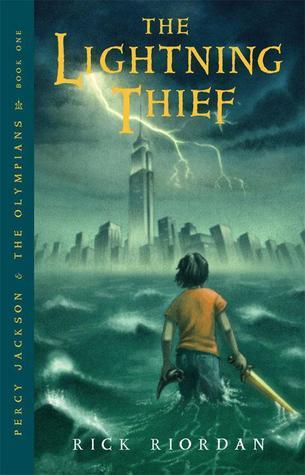 A book cover. The title "The Lightning Thief" is written in large yellow capitals at the top. The author's name "Rick Riordan" is written at the bottom in smaller white capitals. Written vertically down the left side of the cover, the name of the series "Percy Jackson & the Olympian" and "Book One" in smaller yellow capitals. The background shows art of a young boy standing in the sea in front of a New York City cityscape while it is storming. The sea and sky are dark green and grey in colour. The boy is in the foreground, to the right of the cover, with his back to the viewer, with short black hair, an orange t-shirt and jeans. In his left hand, a black horn. In his right hand, a sword. Lightning can be seen coming from the first "I" in "Lightning" and striking over the Empire State Building. /end