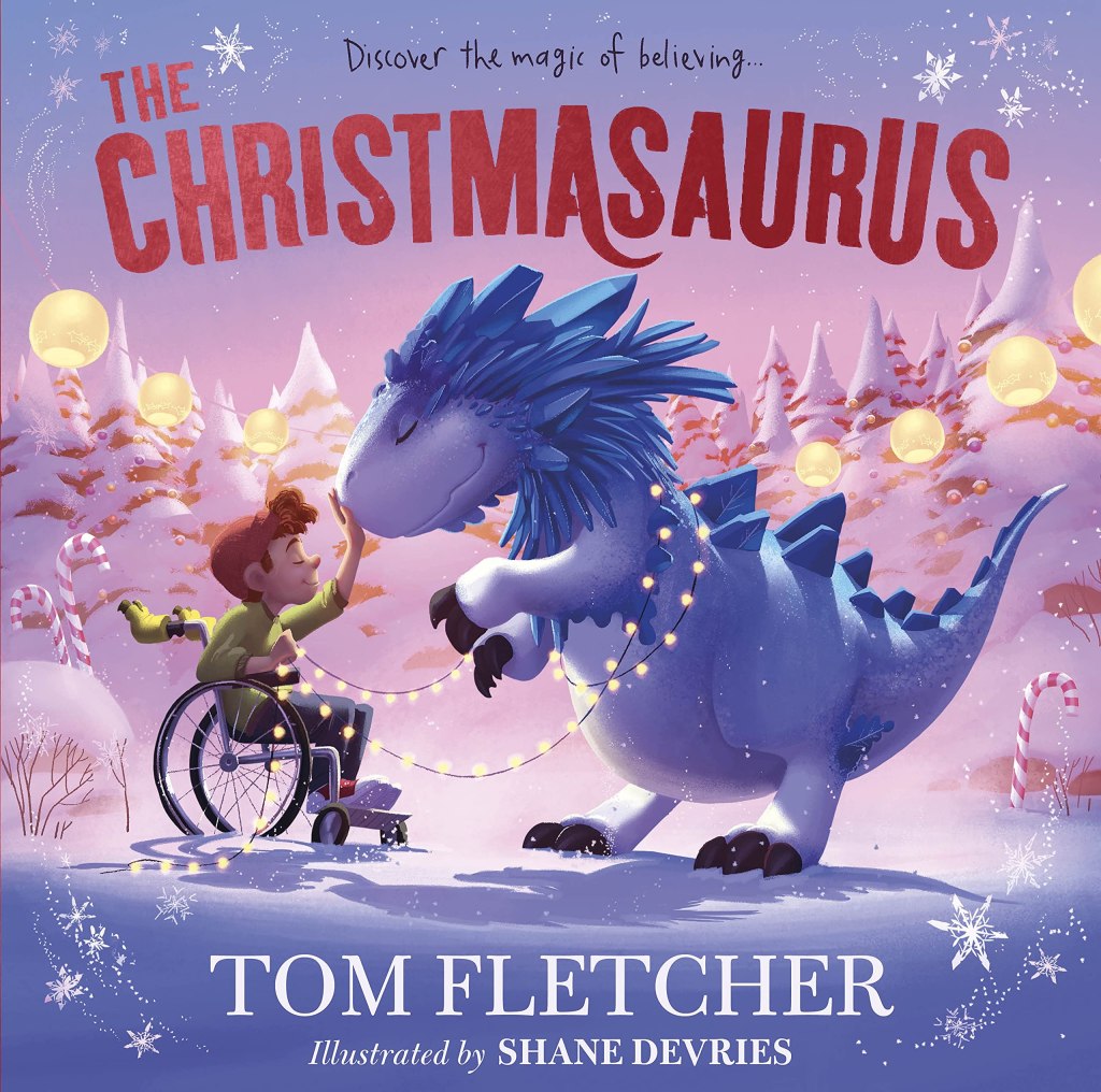 Cover for the picture book The Christmasaurus by Tom Fletcher. The title is written at the top in large red capitals. The author's name is written at the bottom in smaller white capitals. The illustrator's name is written below this in smaller white capitals. Cover art shows a large purple dinosaur and a young person in a wheelchair touching its nose. They are surrounded by snow, snow covered evergreen trees, candy canes and string orb lights. /end